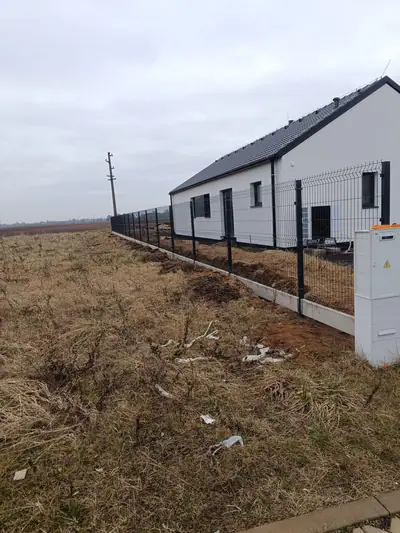 Panelový plot s podhrabovými deskami podél novostavby