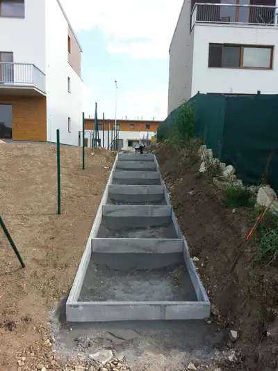 Zahradní schody ve svahu mezi domy, betonové stupně