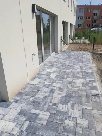Chodník z dlažby v šedomodrém melíru podél domu
