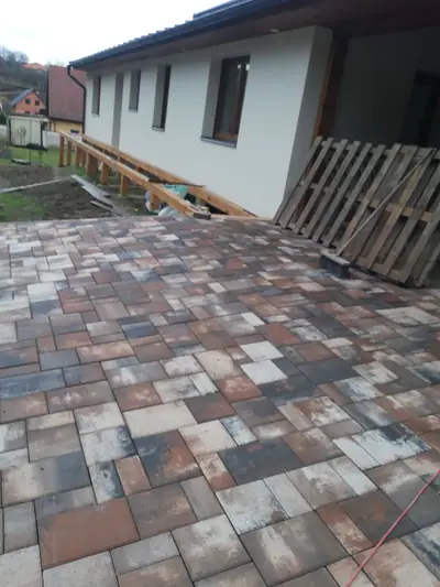 Plocha z dlažby v červenošedém melíru u domu